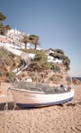white and blue boat on beach during daytime