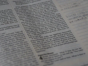 A candid moment of deep concentration during a Torah study session, with notes and a pen in hand.
