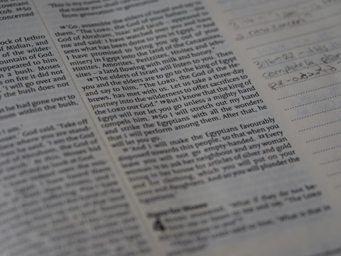 Close-up of hands editing a manuscript filled with Odia script and annotations.