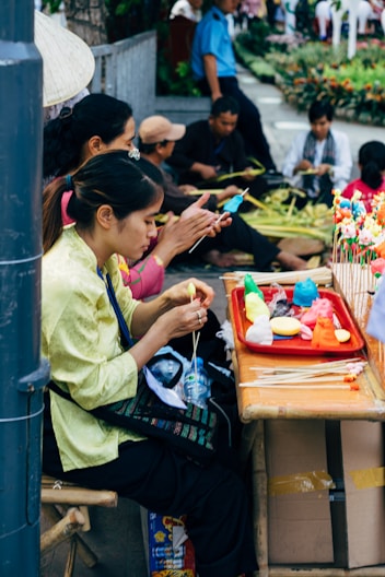 woman in green long sleeve shirt sitting on chair while eating