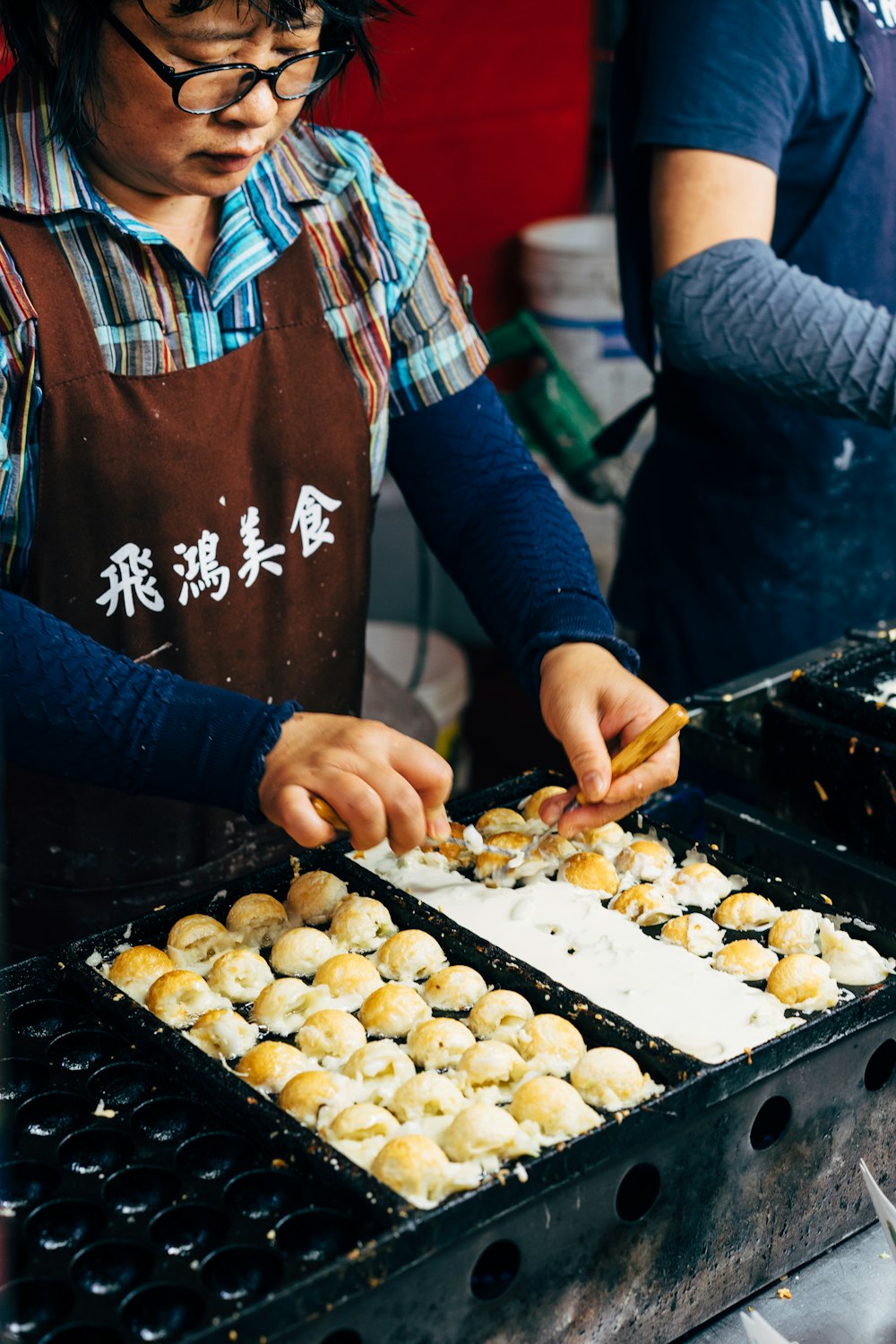 person in blue and red long sleeve shirt holding brown wooden tray with cookies