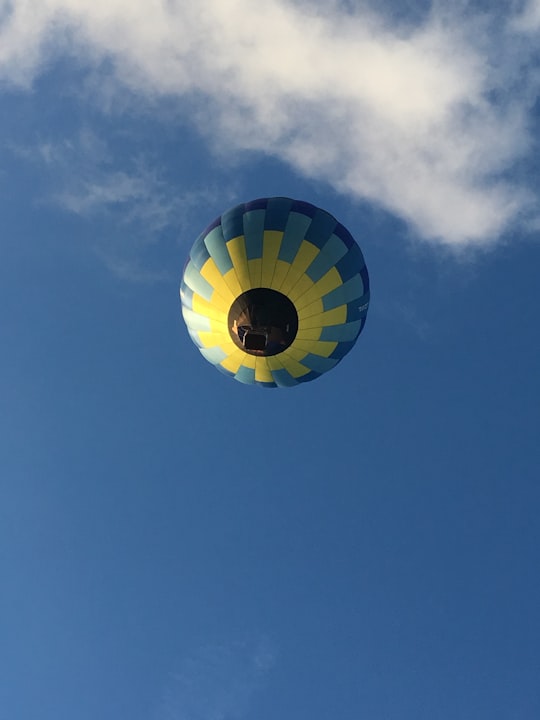 green yellow and blue hot air balloon in mid air under blue sky during daytime in Swansea United Kingdom