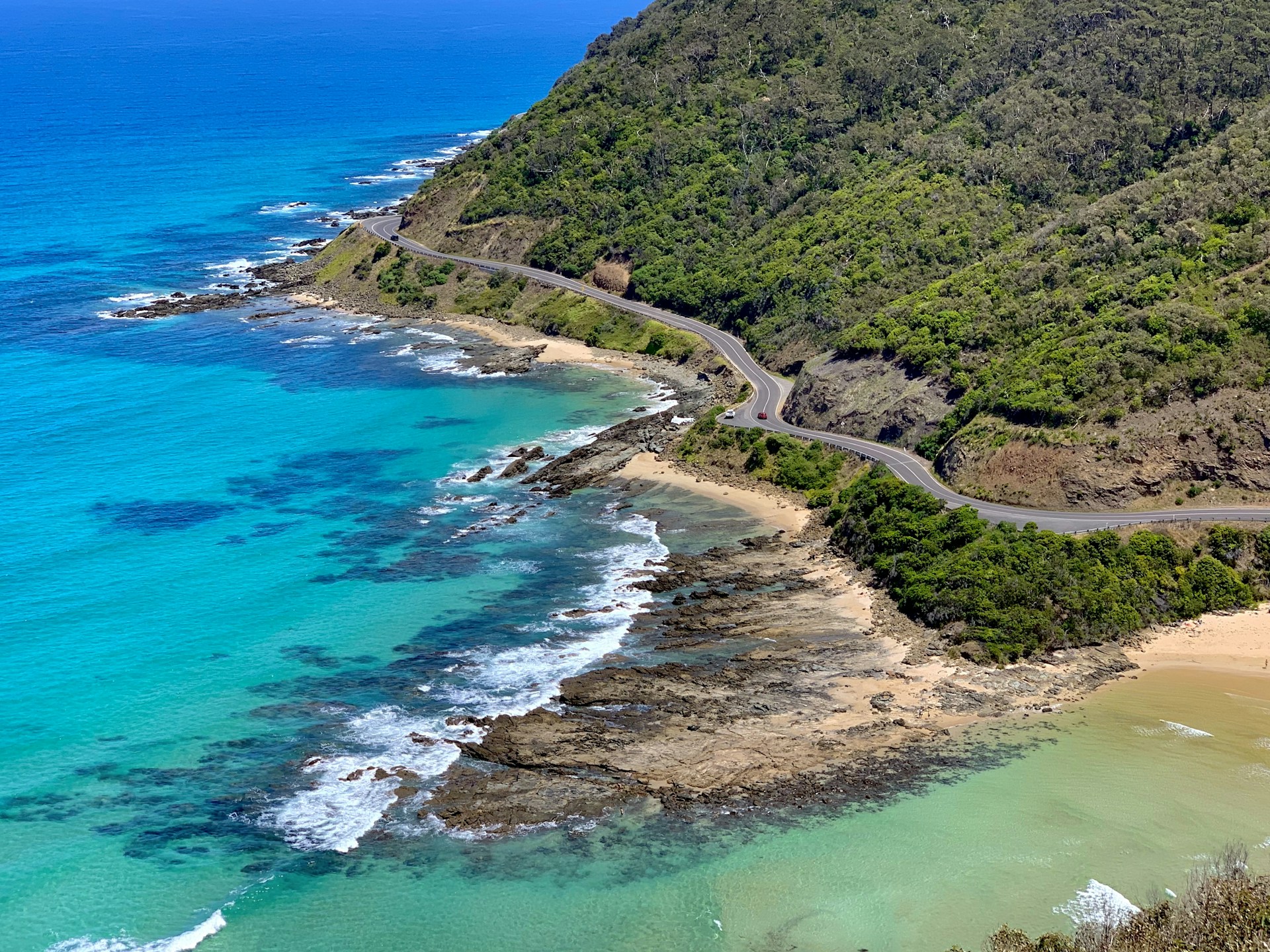 aerial view of green mountain beside blue sea during daytime