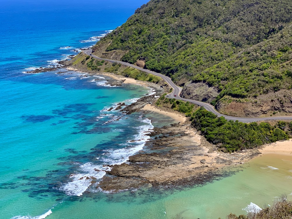 Veduta aerea della montagna verde accanto al mare blu durante il giorno