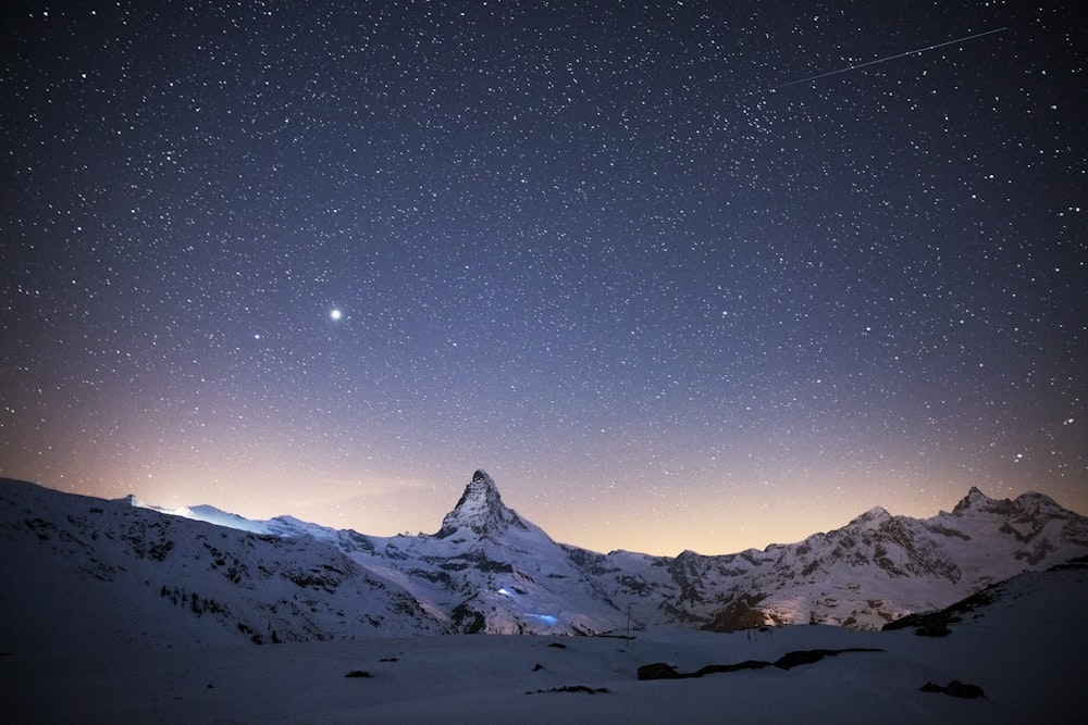 snow covered mountain under blue sky during night time