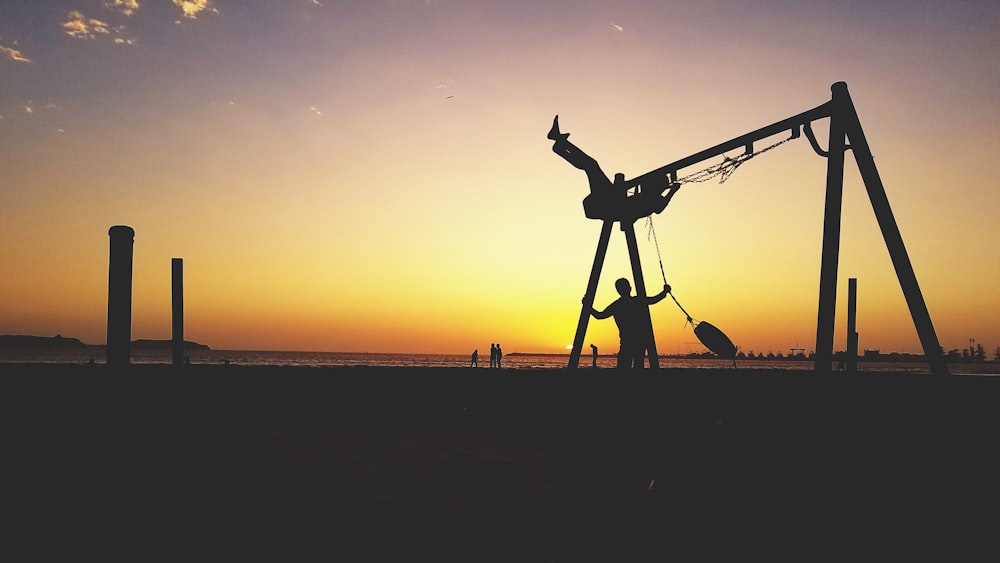 silhouette of man standing on beach during sunset