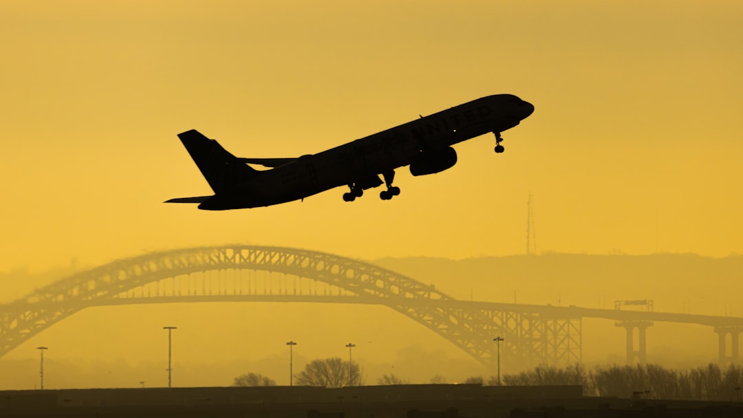 black airplane flying over the city during daytime,
