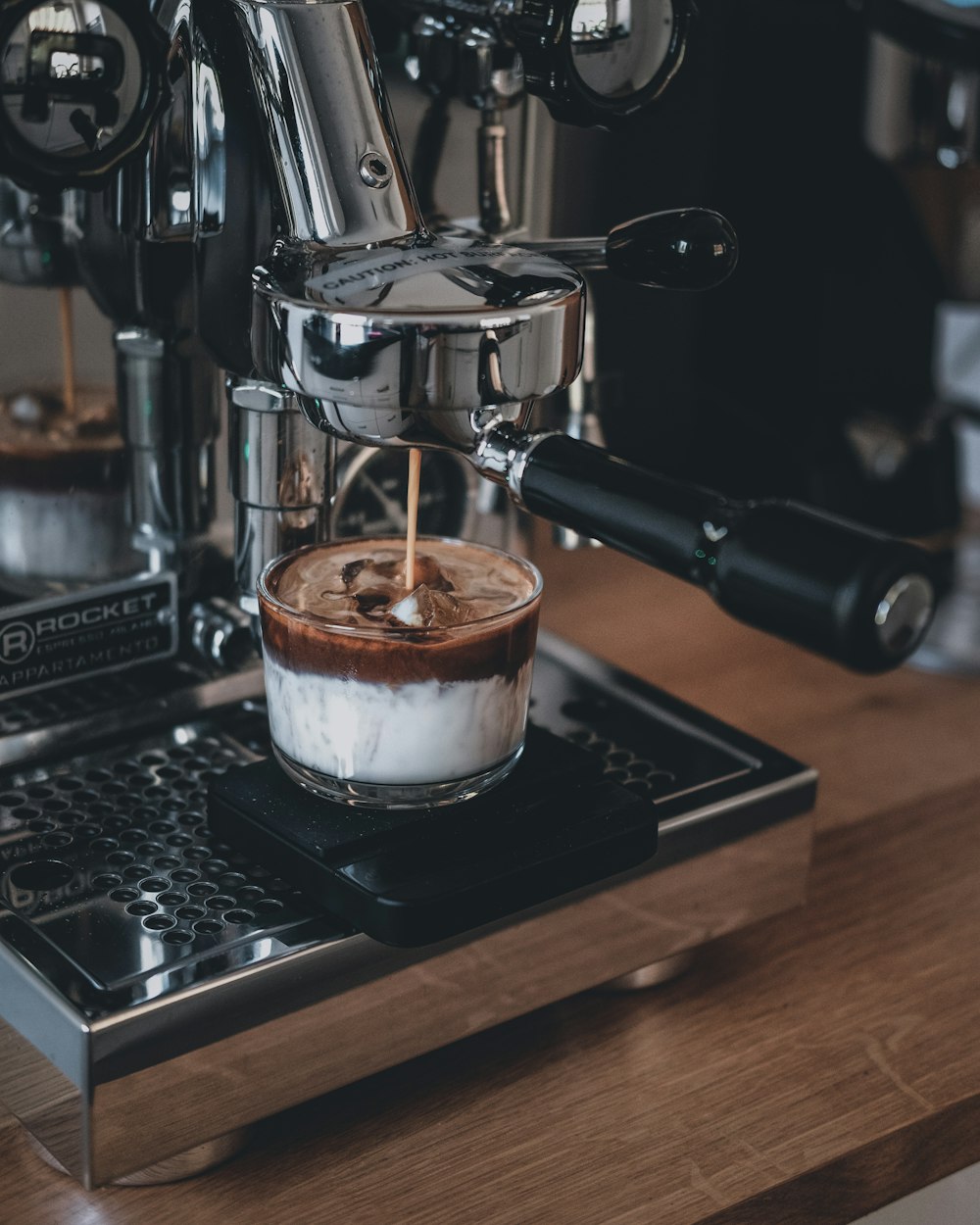 espresso in white ceramic mug on black and silver espresso machine