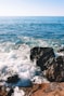 ocean waves crashing on rocky shore during daytime