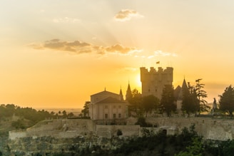A candid shot of Bertie Brosnan filming a historic Irish castle at sunset, capturing the golden light reflecting off ancient stone walls.
