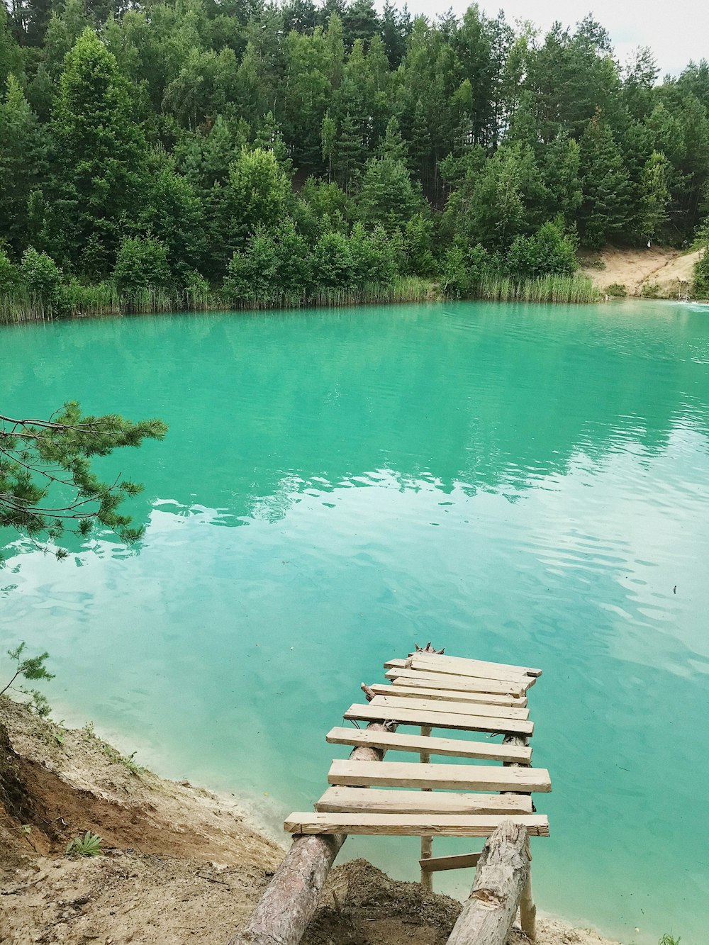 brown wooden bench beside body of water during daytime