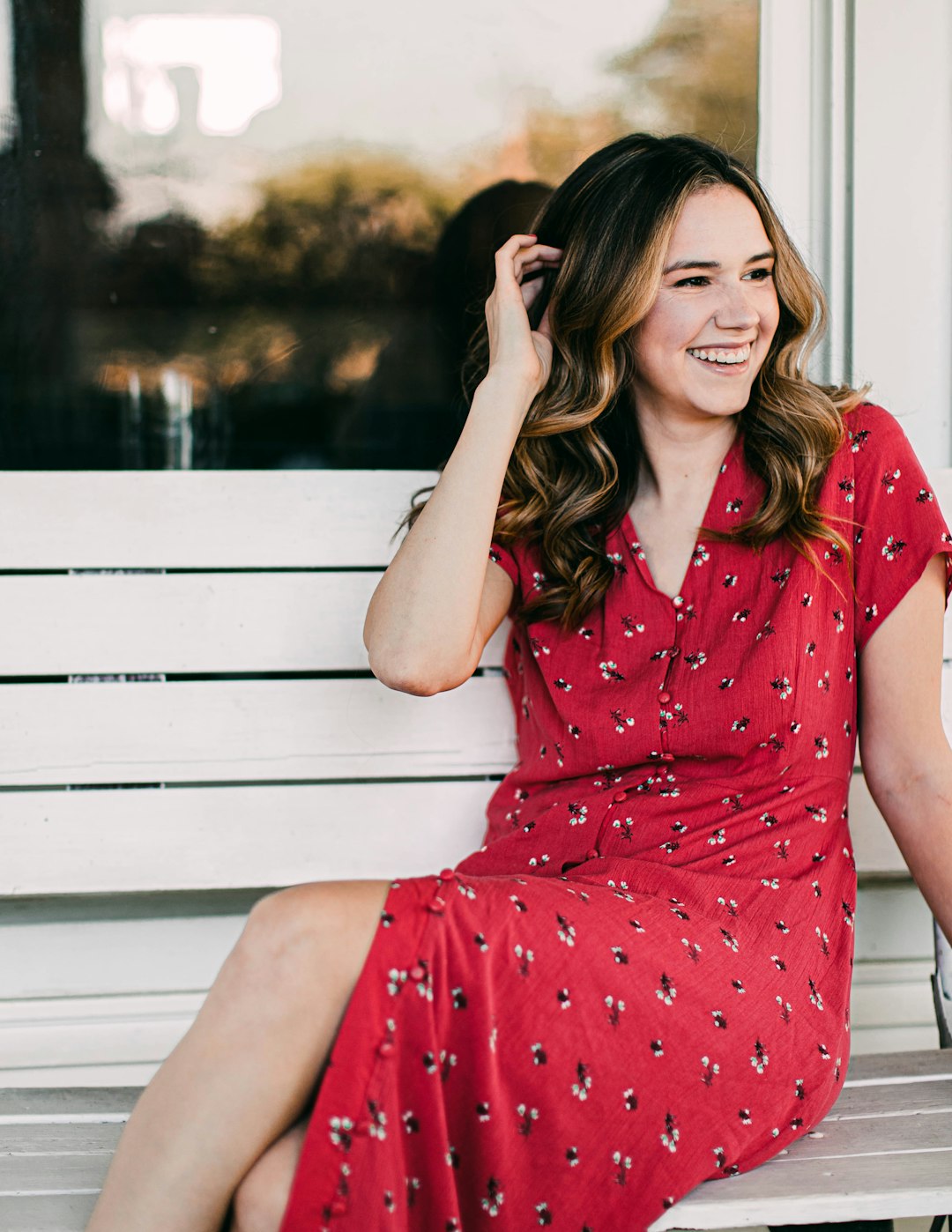 woman in red and white polka dot dress sitting on white wooden bench