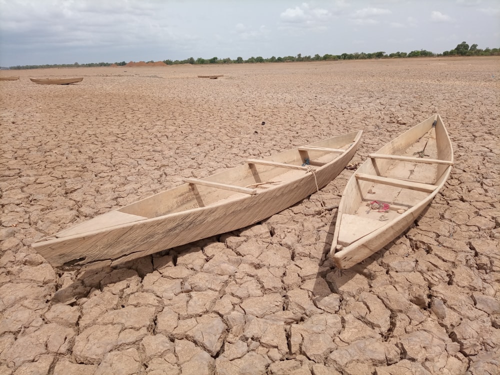 brown wooden boat on brown sand during daytime