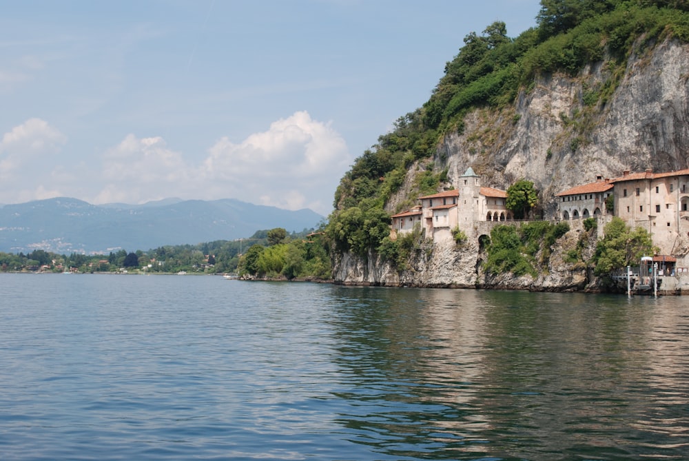 body of water near green trees and mountain during daytime