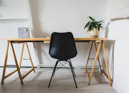 A minimalist workspace with legal books and a black pen on a white desk