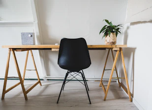 A minimalist workspace with legal books and a black pen on a white desk