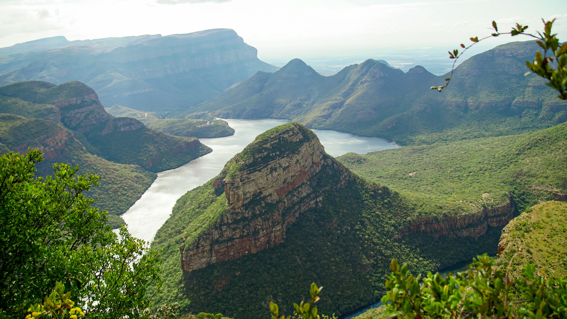 green and brown mountain beside body of water during daytime