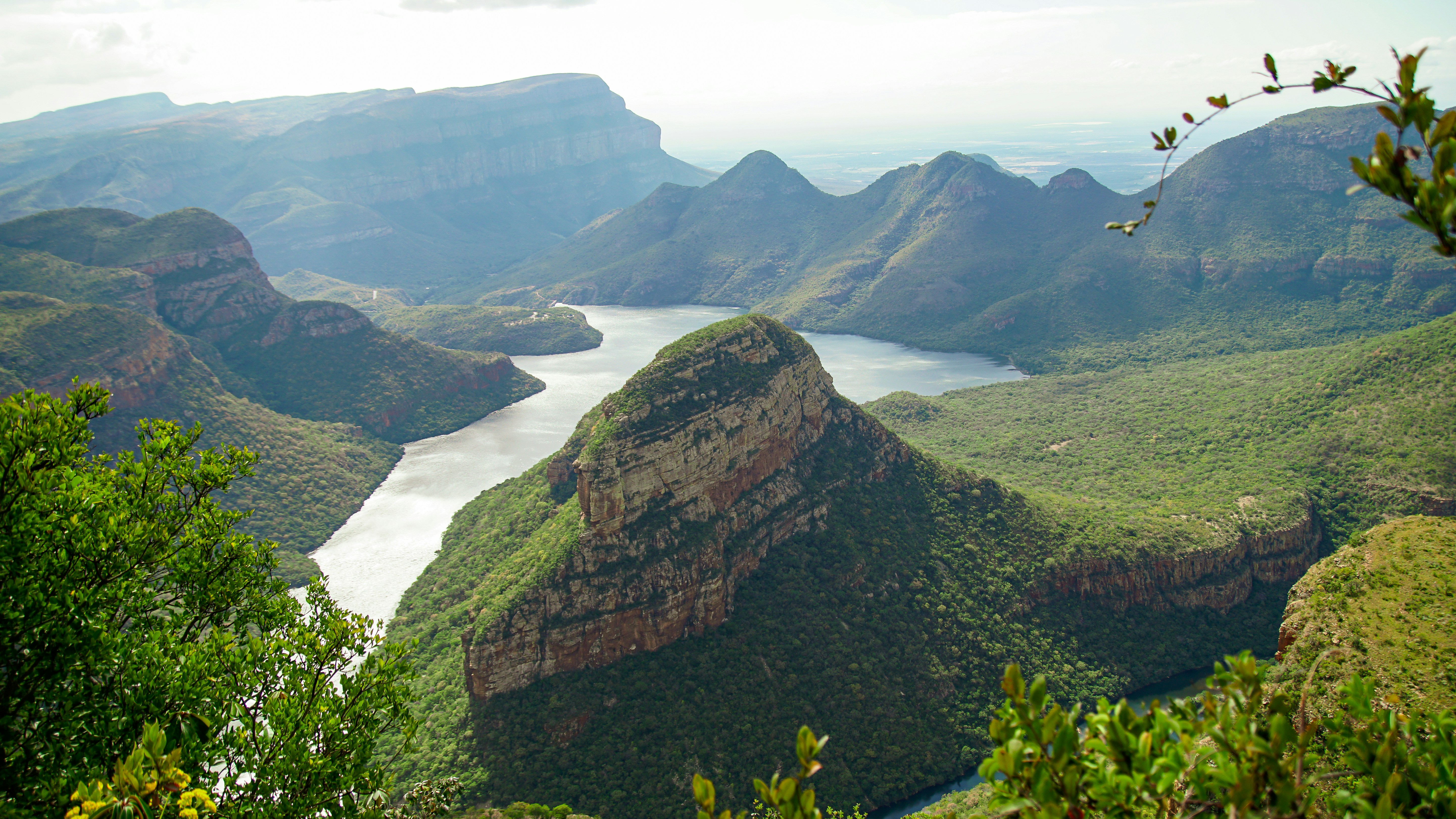 green and brown mountain beside body of water during daytime
