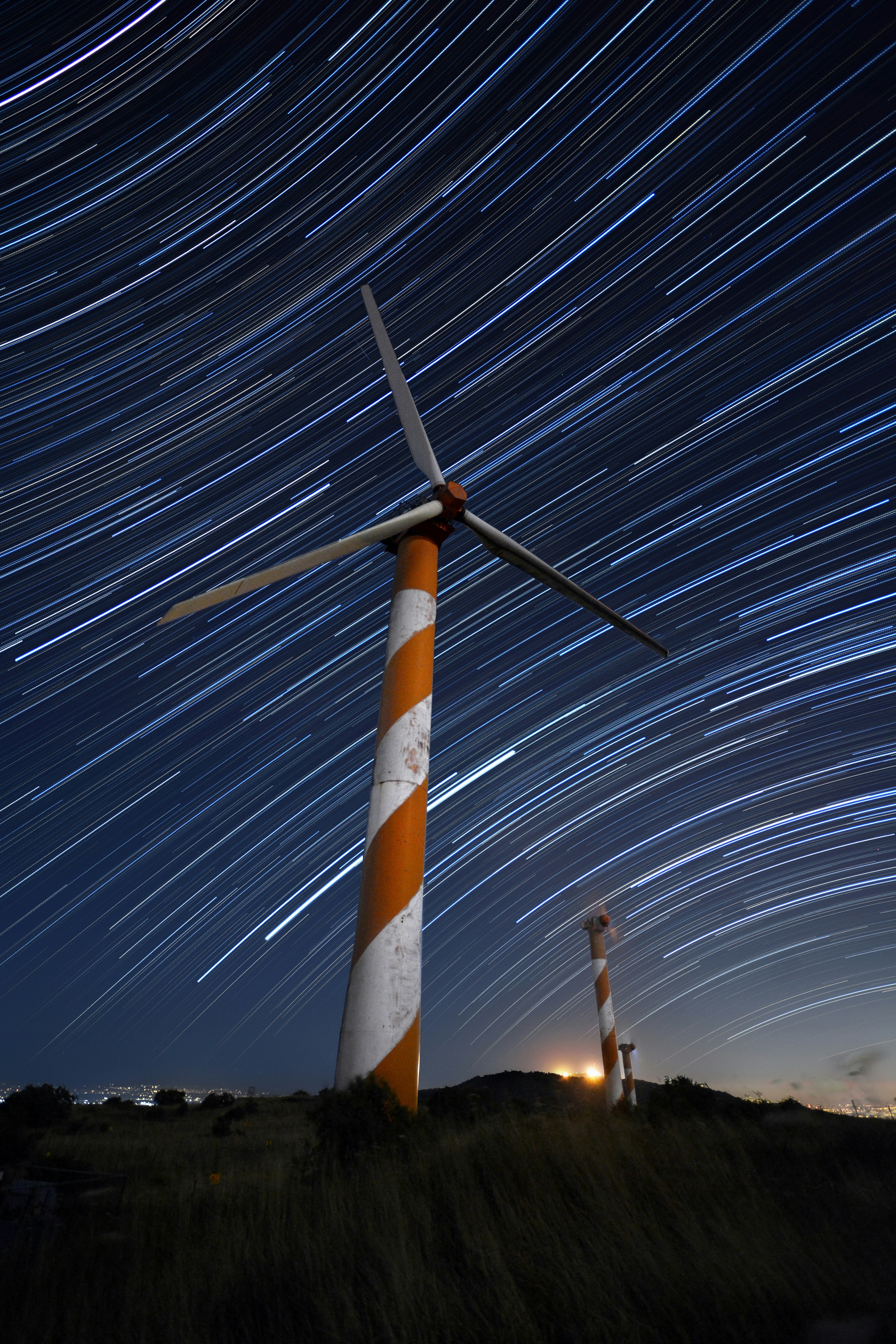 white and orange wind turbine during night time