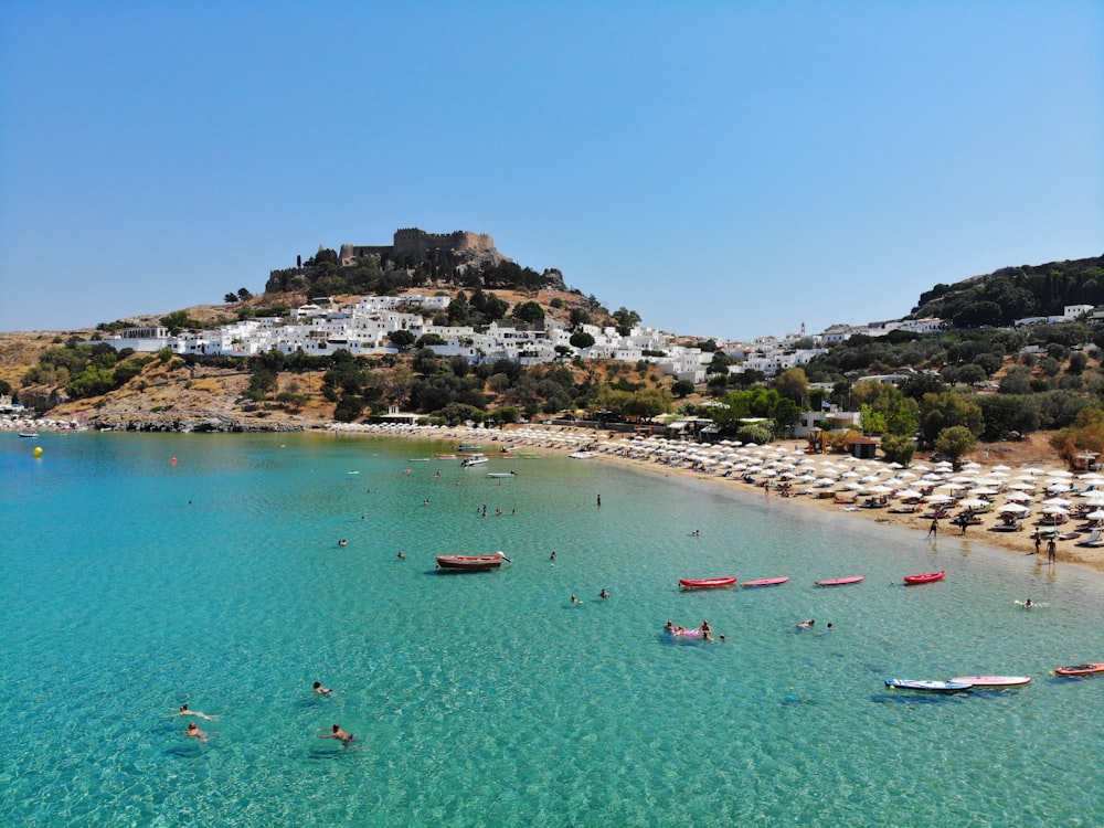 people riding on boat on sea near mountain during daytime