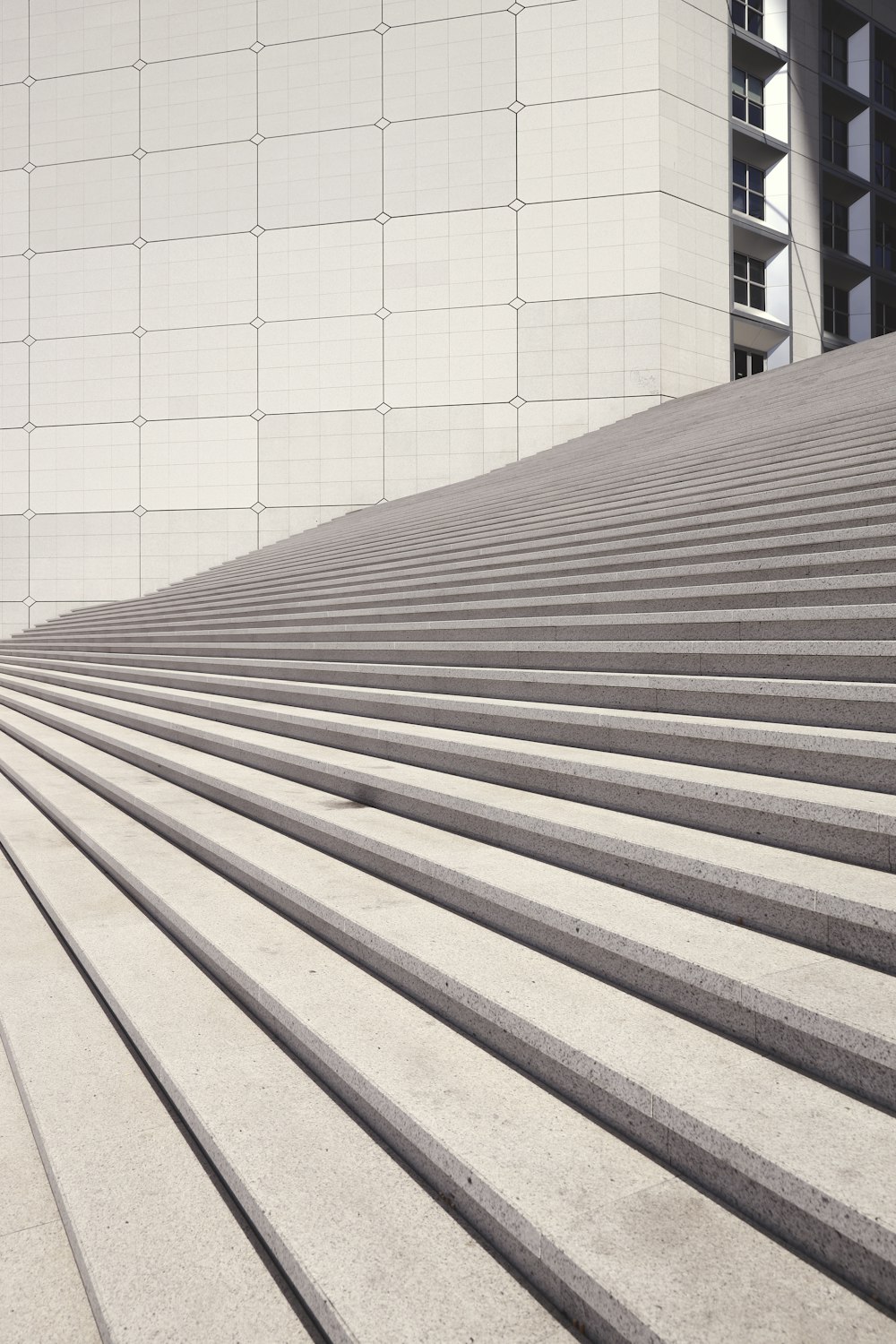 Escaleras de madera marrón cerca de un edificio de hormigón blanco