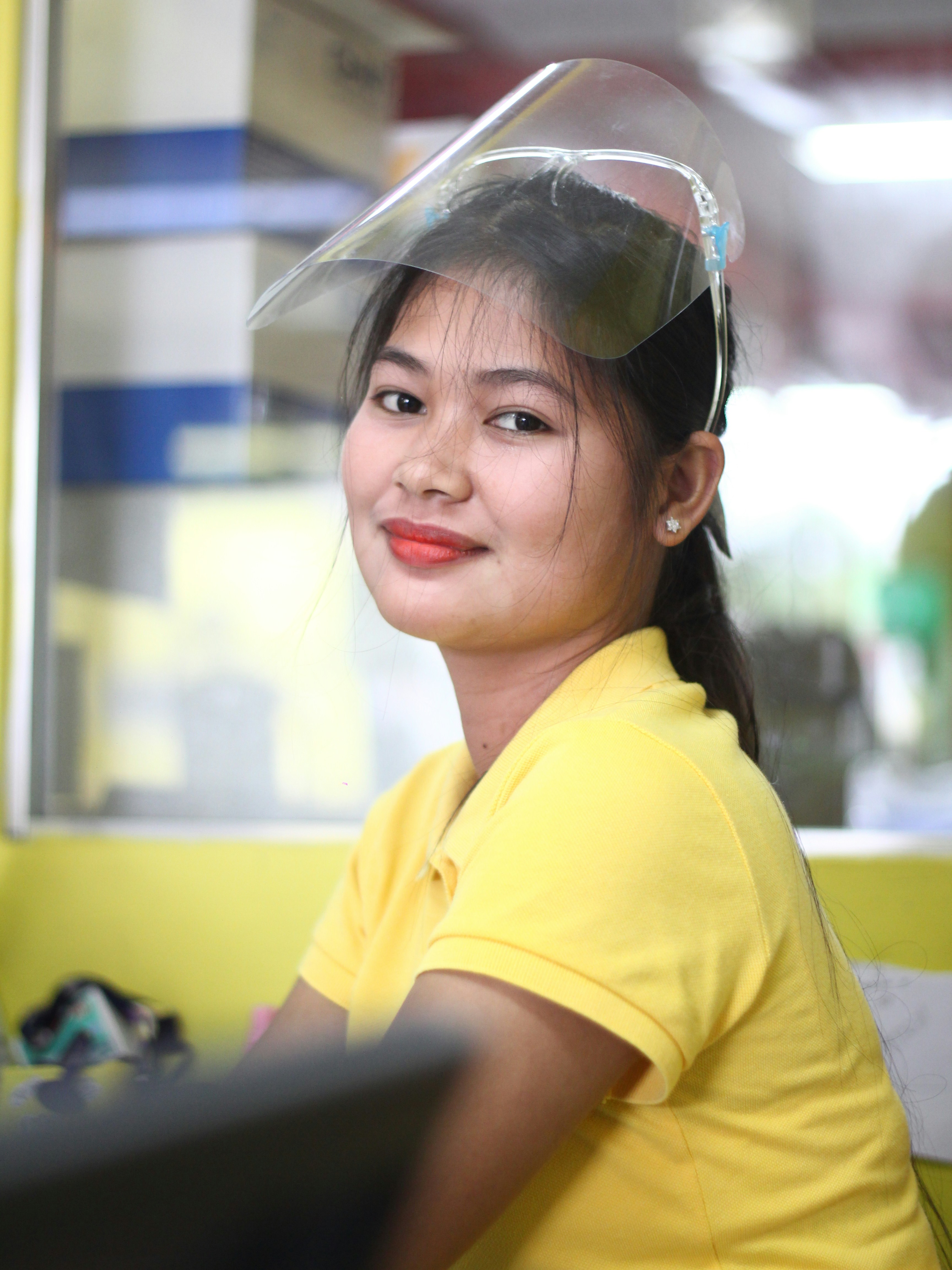 Frau im gelben Poloshirt mit schwarzer Sonnenbrille