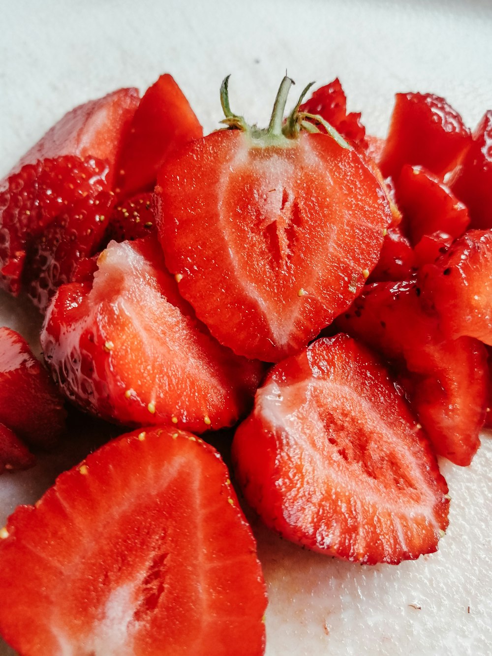 sliced strawberries on white textile