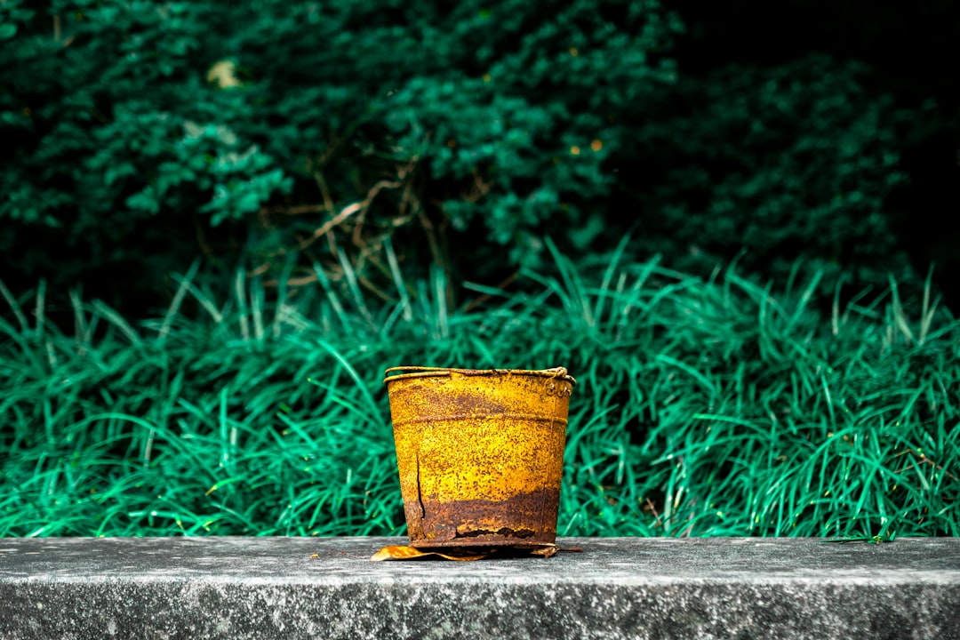  yellow and red steel bucket on gray concrete surface bucket