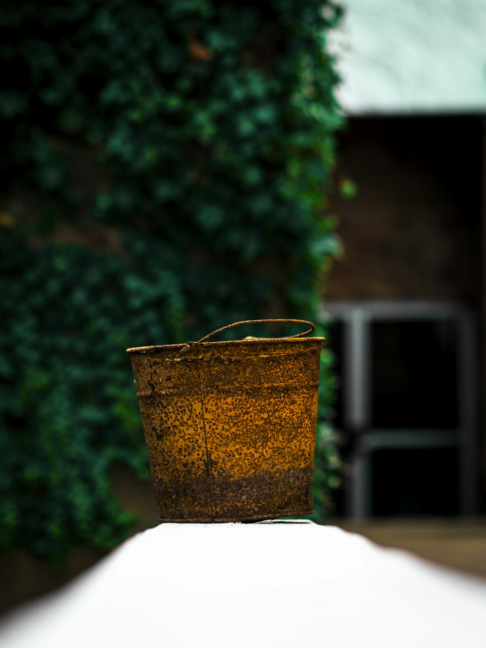 brown metal bucket on white table