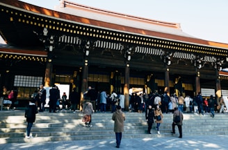 people walking in front of a shrine during daytime