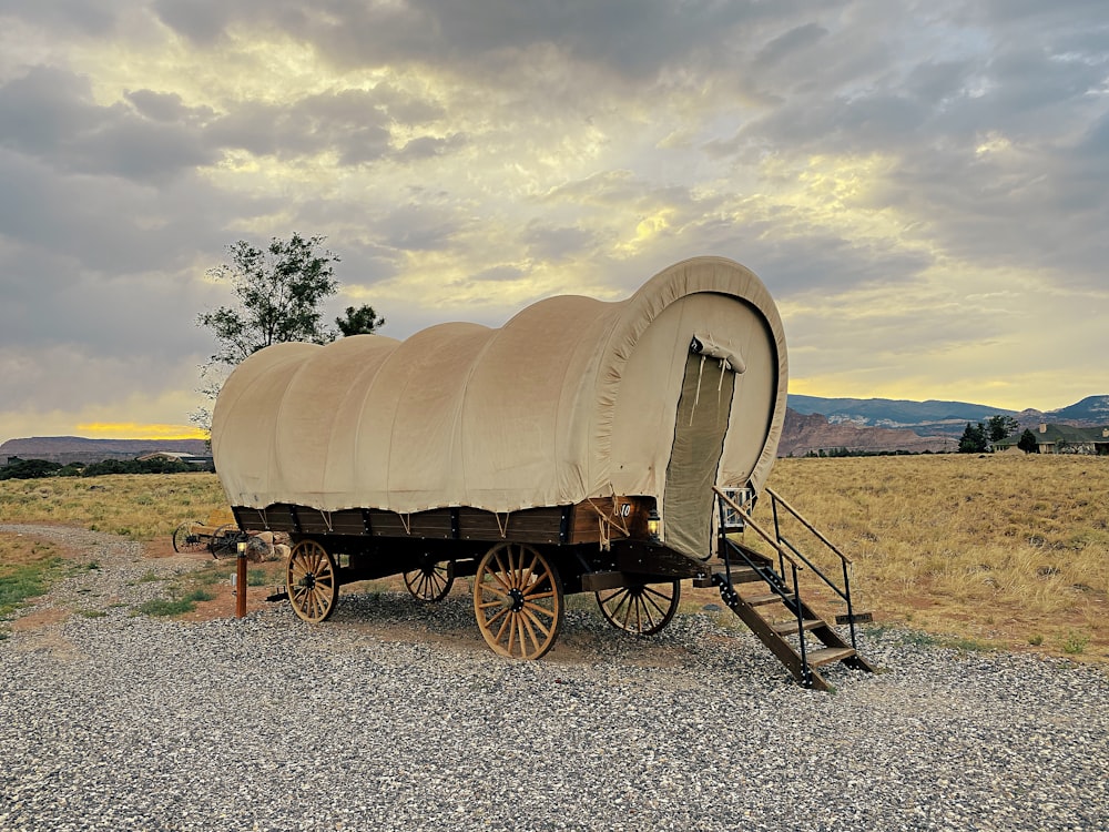 brown wooden carriage on gray sand during daytime