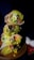 Three cross-sections of stacked burritos on a wooden surface, revealing ingredients such as lettuce, corn, tomato, rice, and some type of meat filling. In the background, there are garlic cloves and a chili pepper partially visible.