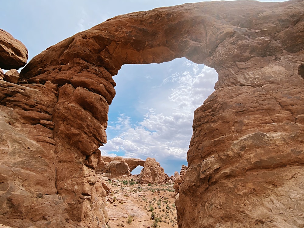 brown rock formation under blue sky and white clouds during daytime