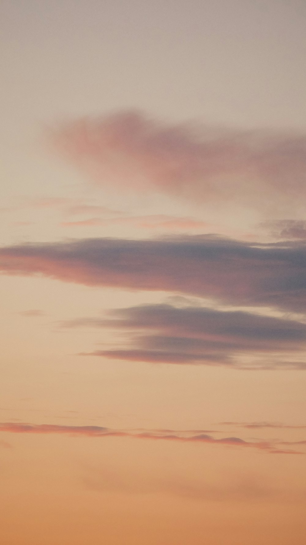 nuvens alaranjadas e cinzas durante o pôr do sol