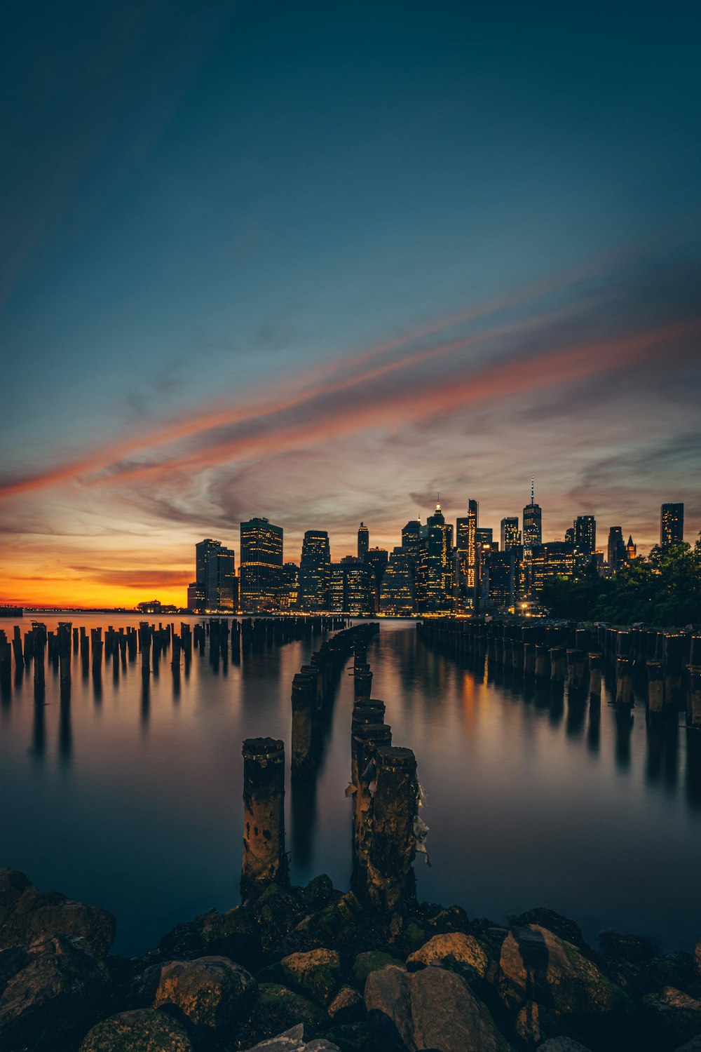 city skyline across body of water during sunset