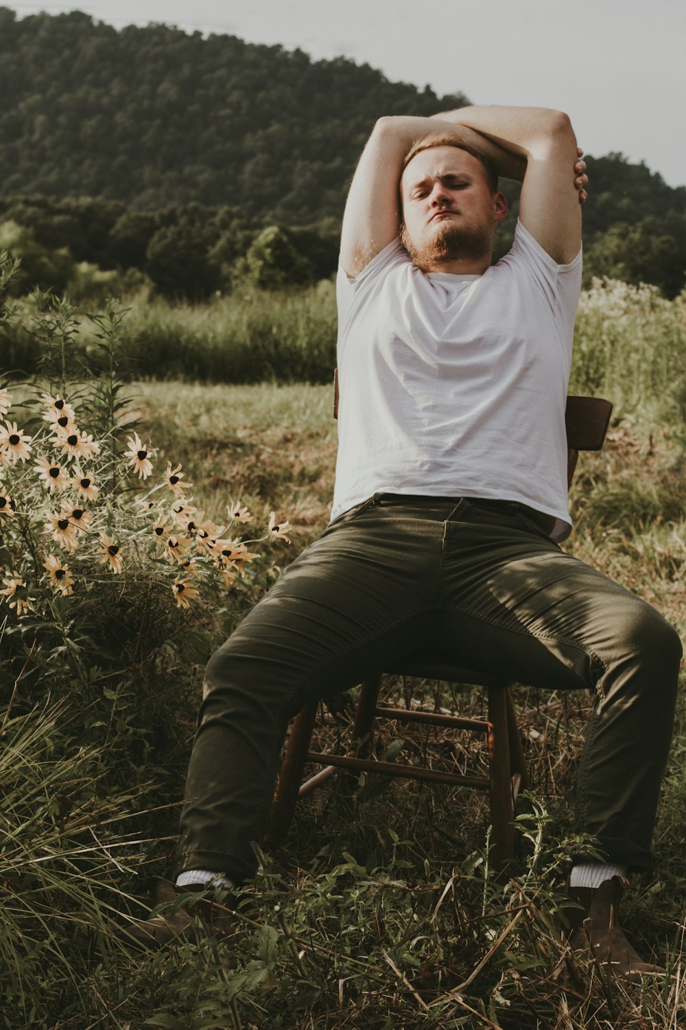 a man sitting in a chair in a field