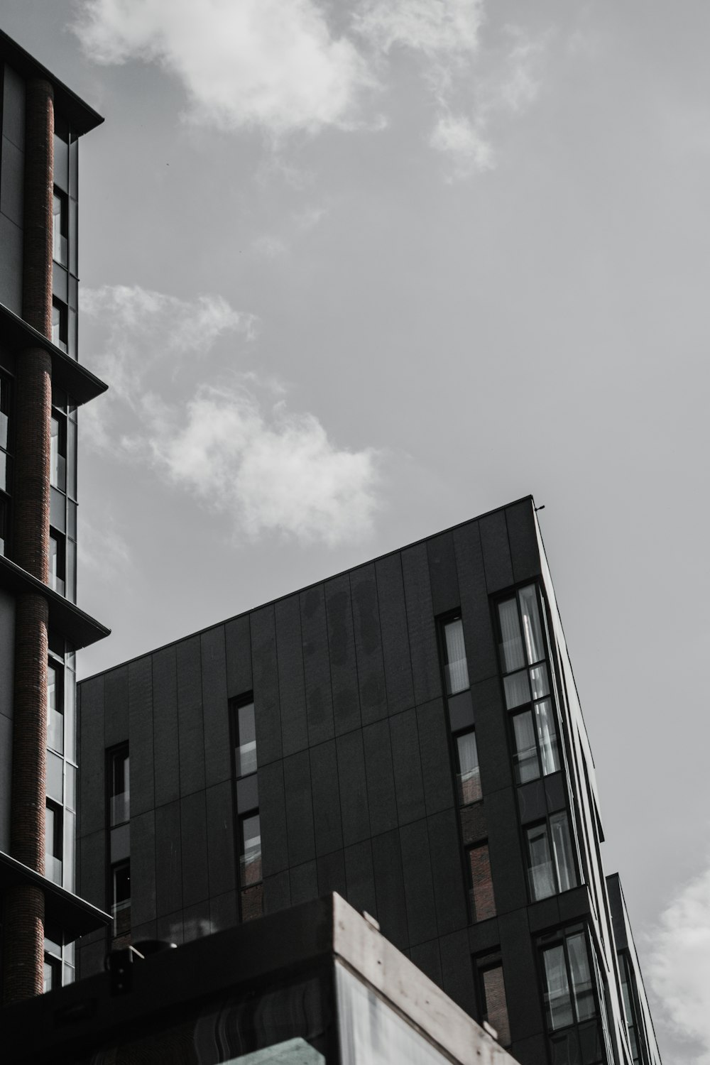 black and brown concrete building under white clouds