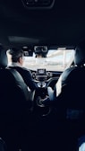 man in black suit driving car during daytime