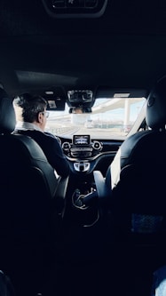 man in black suit driving car during daytime