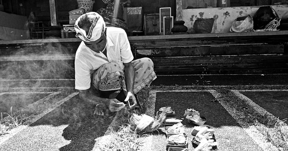 a black and white photo of a man sitting on the ground