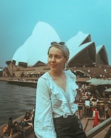 woman in white floral long sleeve shirt standing near body of water during daytime