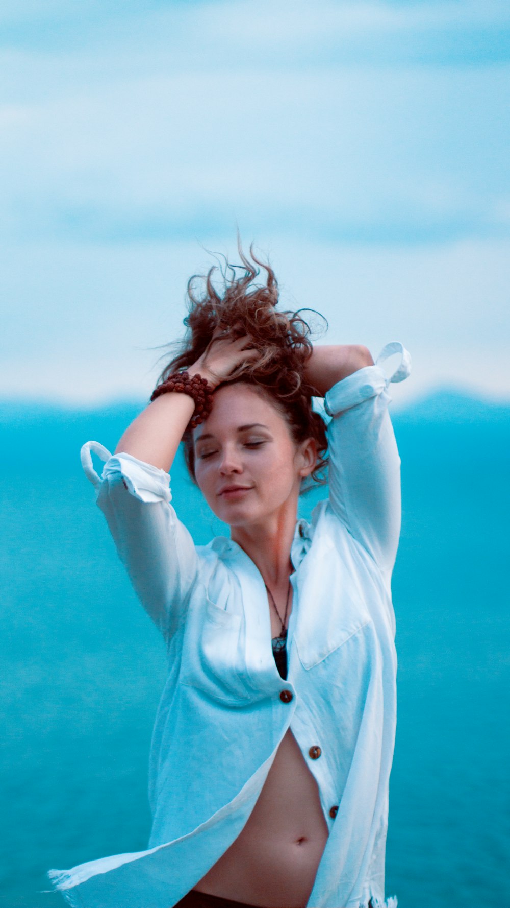 woman in blue button up shirt smiling