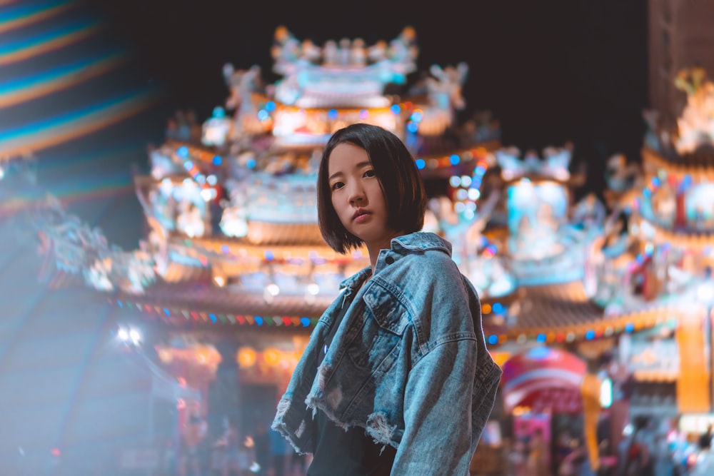 woman in blue denim jacket standing in front of store