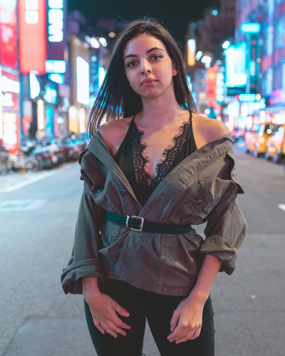 woman in black leather jacket standing on road during daytime