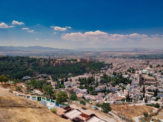 A serene landscape of a Spanish city with historic architecture and a clear blue sky.