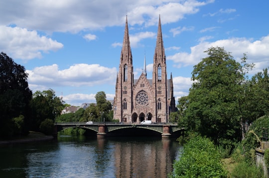 brown concrete building near river during daytime in Reformed Church Saint Paul France