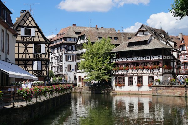 White and brown concrete building beside river during daytime — Strasbourg, France
