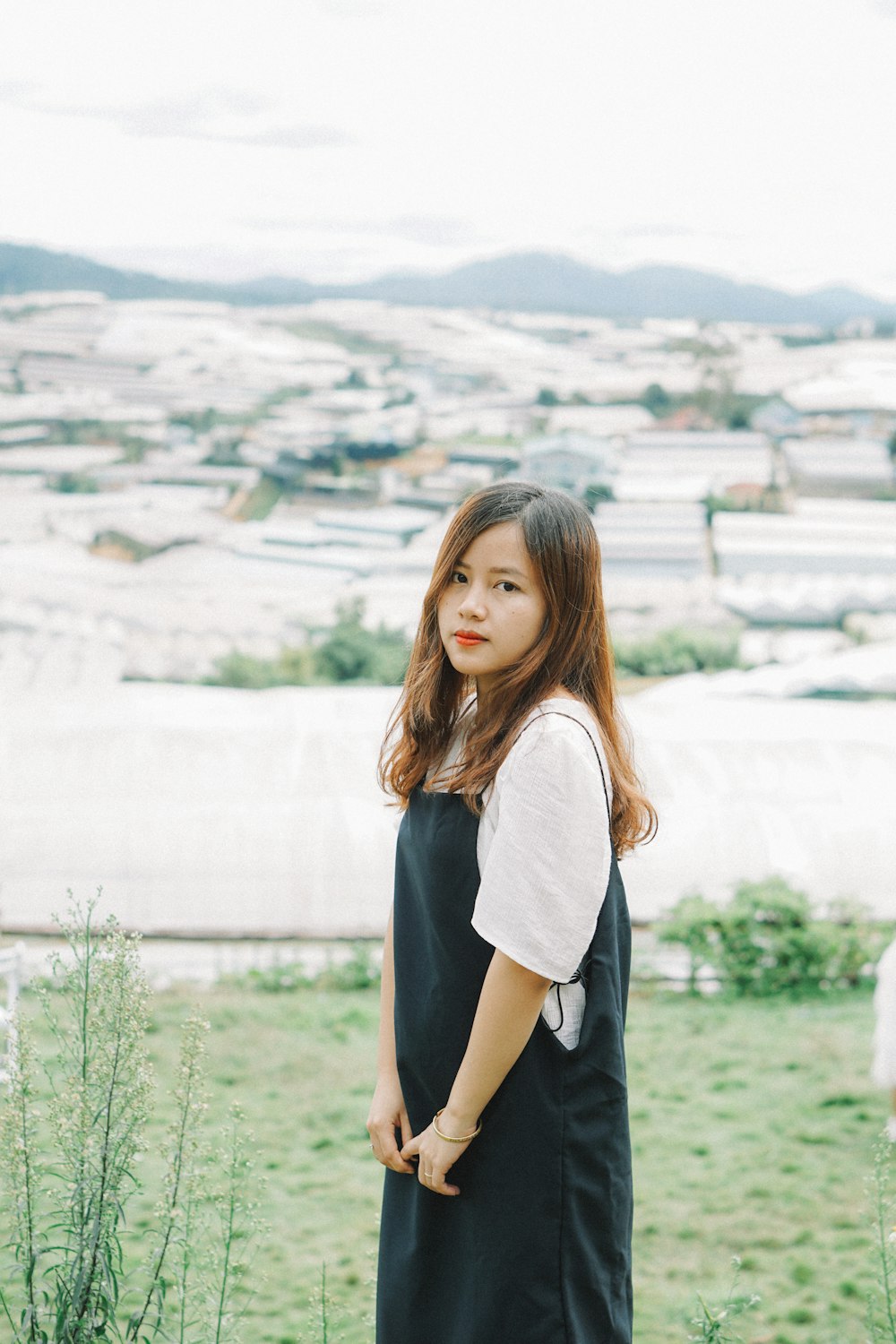 a woman in a black dress standing in a field