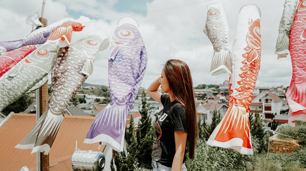 woman in black dress standing beside white owl statue