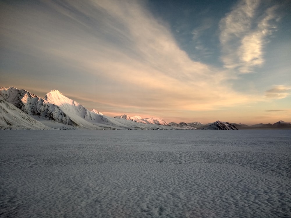 snow covered mountain during sunset